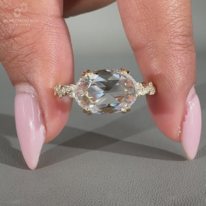 East west engagement ring with hidden halo and twisted pave band.
