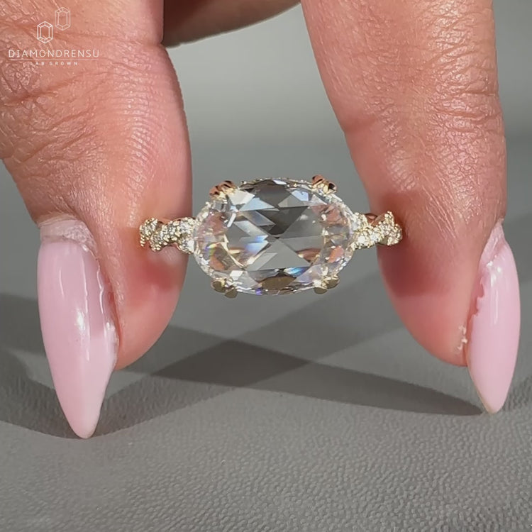 East west engagement ring with hidden halo and twisted pave band.
