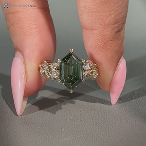 Green diamond hexagon ring with round side stones.