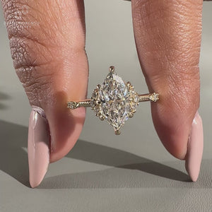 Marquise diamond ring round side stones milgrain set.
