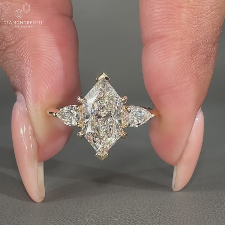 Marquise diamond ring pear side stones tapered shank.
