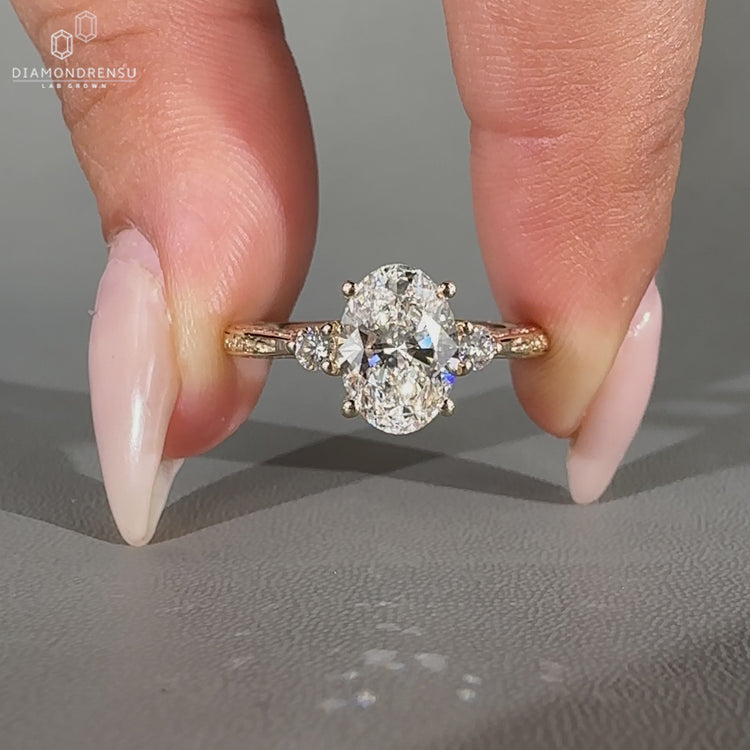 Oval diamond ring round side stones tapered shank set.
