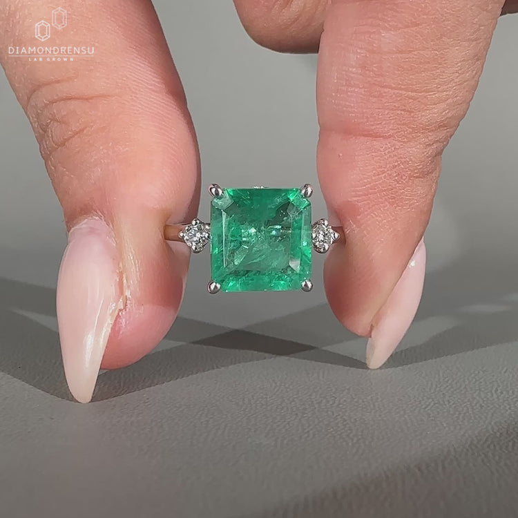 Asscher cut emerald ring hidden halo round diamond set.
