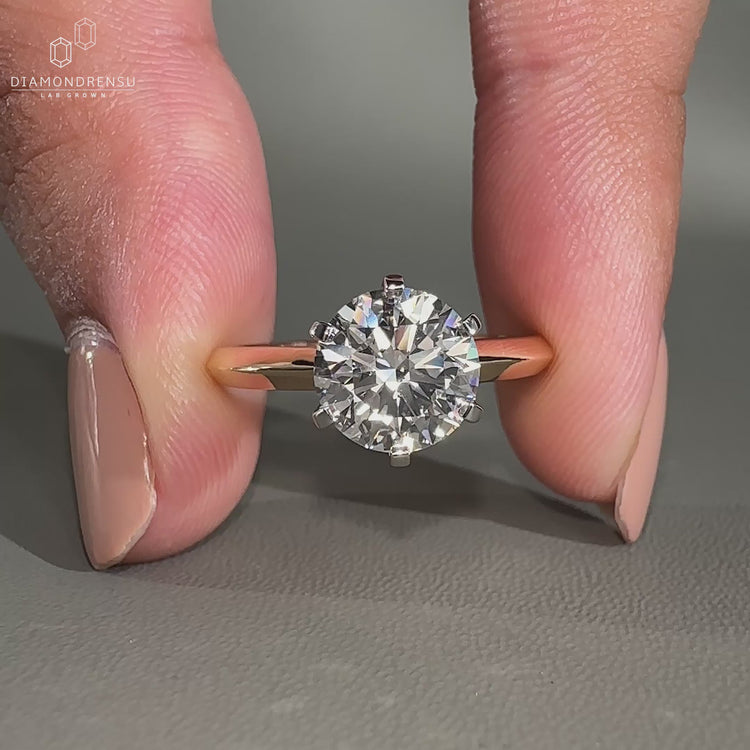 Round cut diamond ring designed in a classic yellow gold setting.

