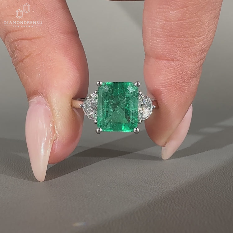 Emerald gemstone ring half moon stones cathedral set.
