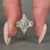 Trapezoid step cut side stone and v prong setting used.
