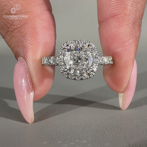 Cushion cut diamond ring with pavé diamonds and double claw prong setting.
