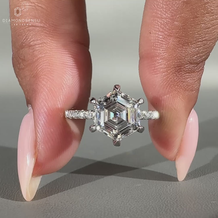 Hexagon cut diamond ring with hidden halo and pavé setting.
