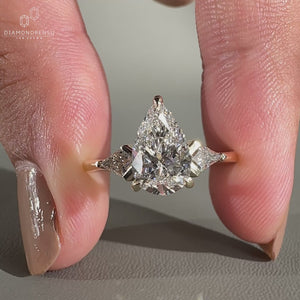 Pear cut diamond ring paired with kite cut side stones ring.
