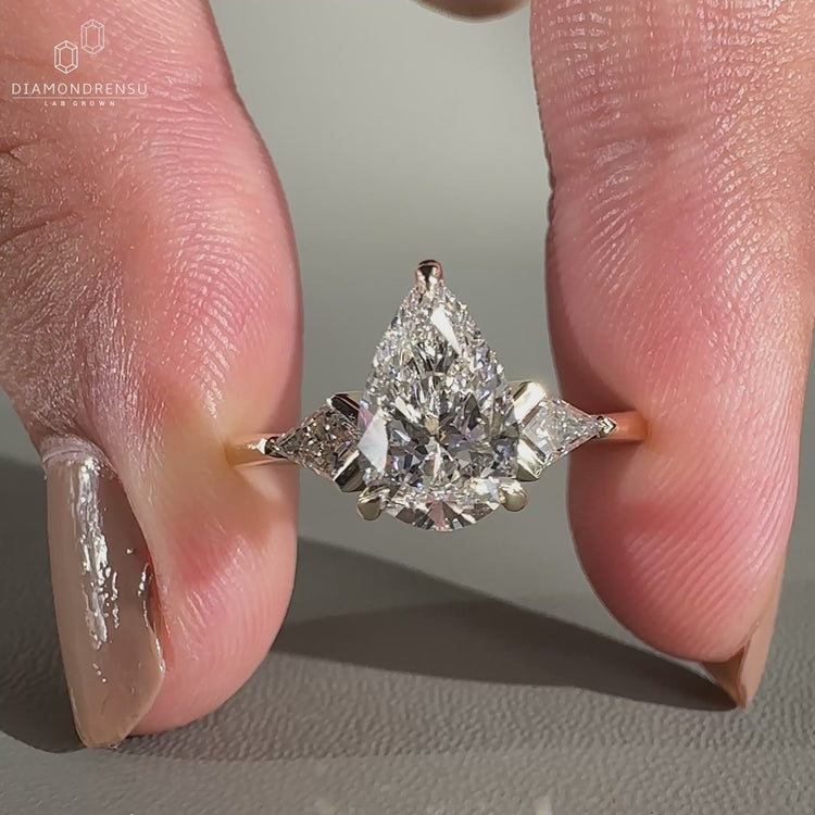 Pear cut diamond ring paired with kite cut side stones ring.
