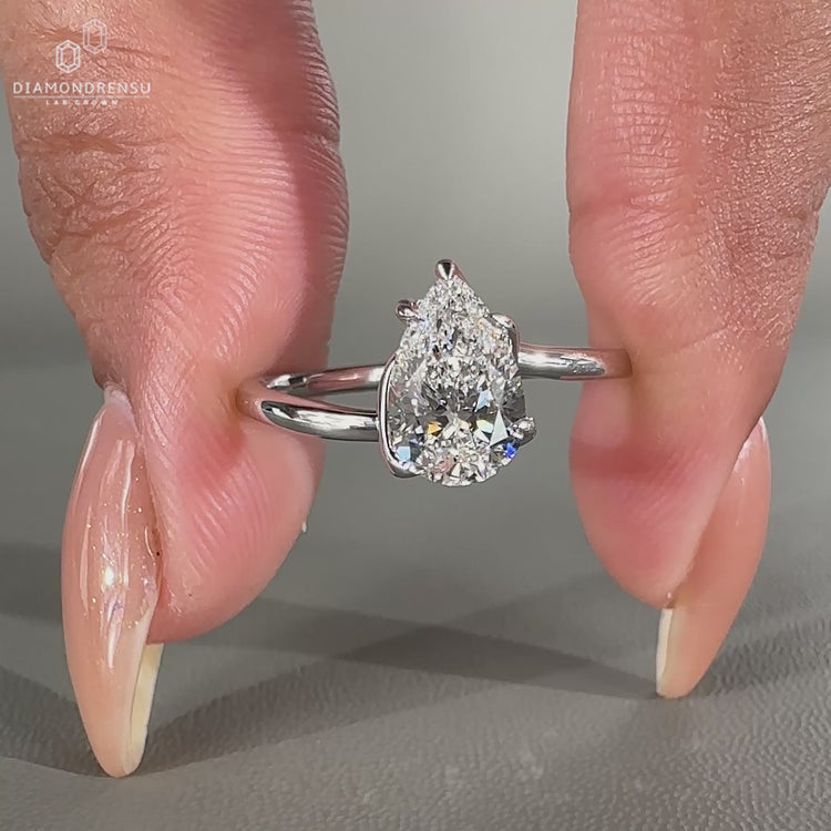 Pear cut diamond engagement ring with twisted band and solitaire setting in white gold.
