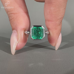 Asscher gemstone ring emerald bezel round diamond band.
