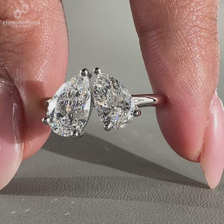 Pear diamond ring with two stone design and prong setting.
