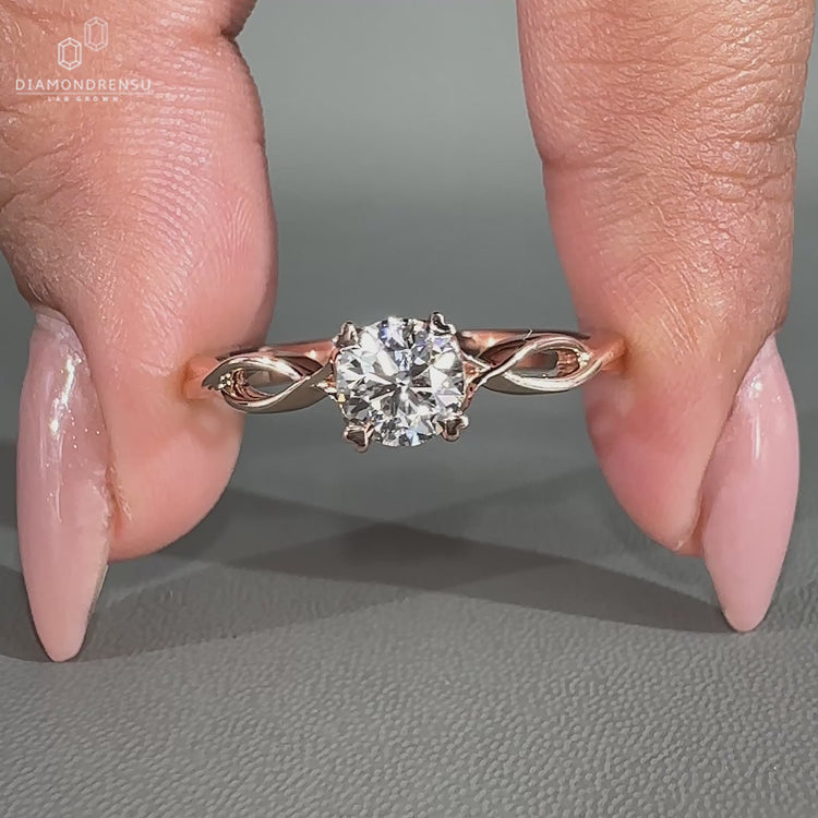 Round cut diamond ring with four heart prong setting in rose gold.
