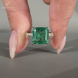 Asscher emerald ring pave band round diamond prong set.
