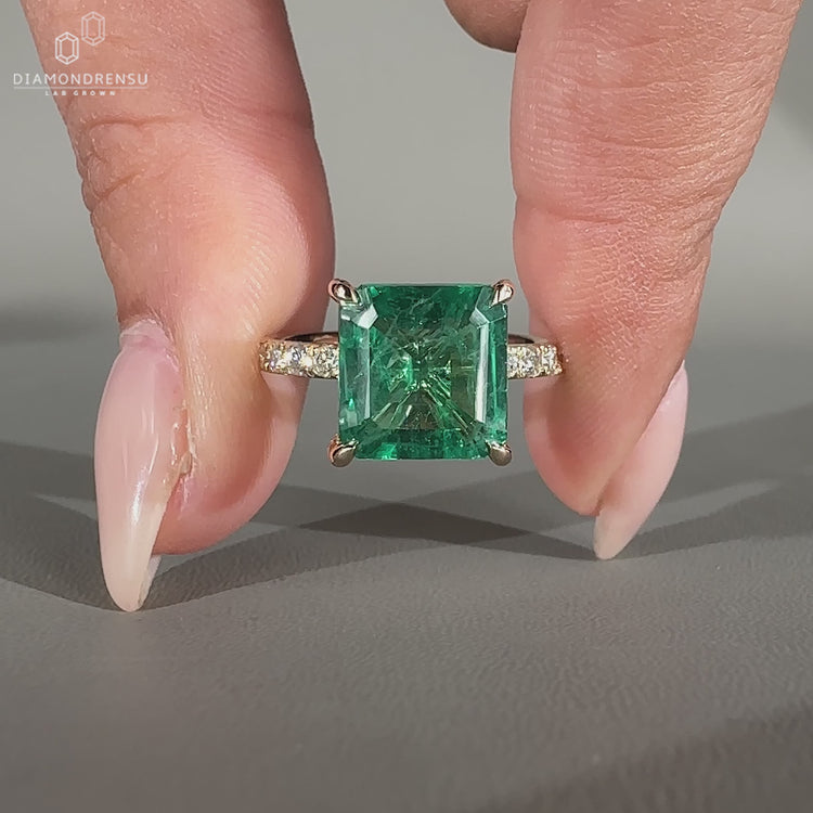 Asscher emerald ring pave band round diamond prong set.
