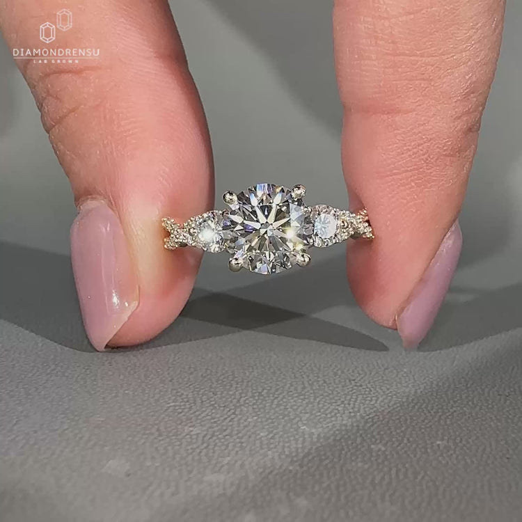 Round diamond ring two side stones twisted shank style.