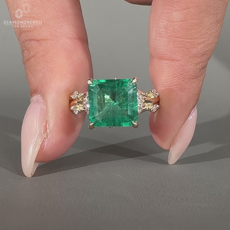 Asscher cut emerald ring nature cluster twisted shank set.
