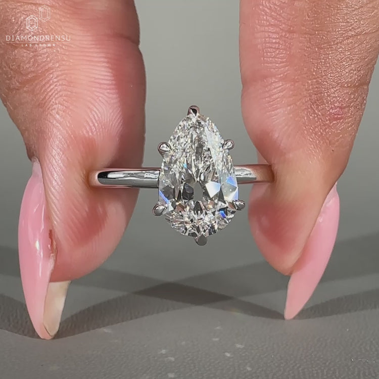 Solitaire diamond ring with a pear shaped diamond and white gold band.
