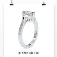Three stone ring emerald cut with trillion cut side stones for a unique look.